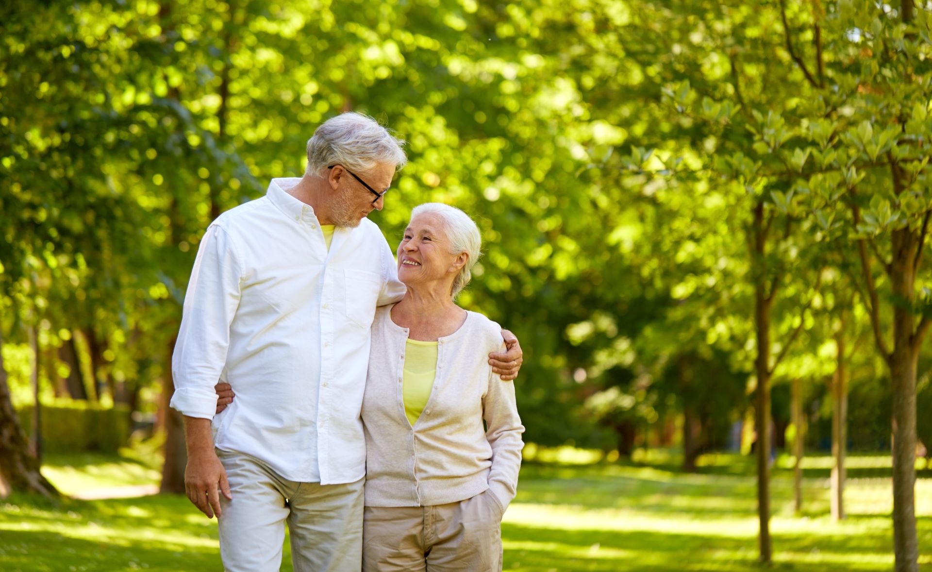 An older couple walking through a park