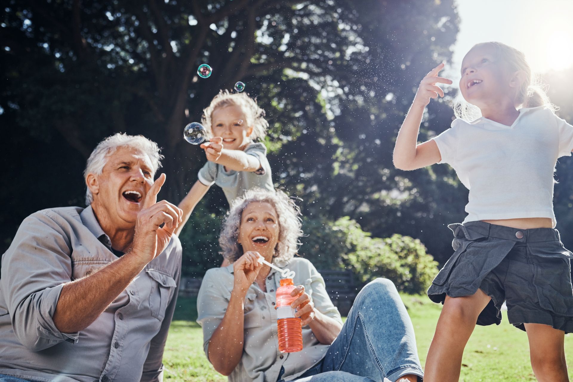 grandchildren blowing bubbles with their grandchildren